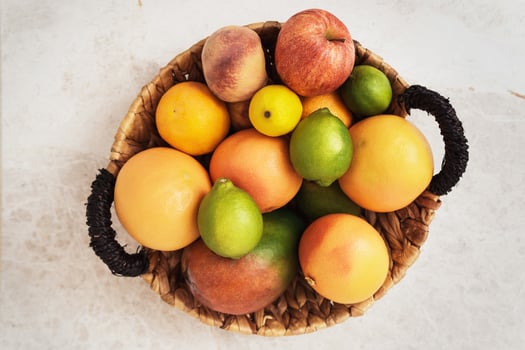 Basket with a lot of different fruits such as apple, peach, orange, lemon grapefruit and mango photo