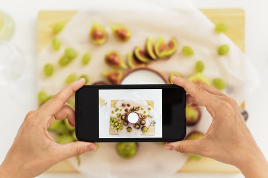 Woman taking photo  of her delicious Greek yogurt with figs by her smartphone