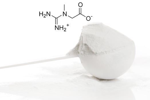 Scoop of creatine monohydrate supplement and chemical formula photo