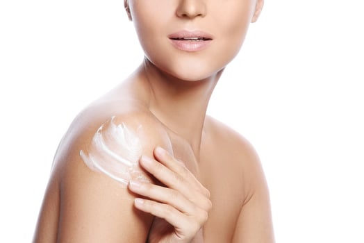 Young and beautiful woman with applying moisturizing cream on her shoulder photo