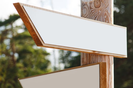 Wooden signpost with blank arrows pointing in different directions. photo