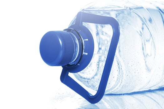 Blue bottle of cold mineral water on white background photo