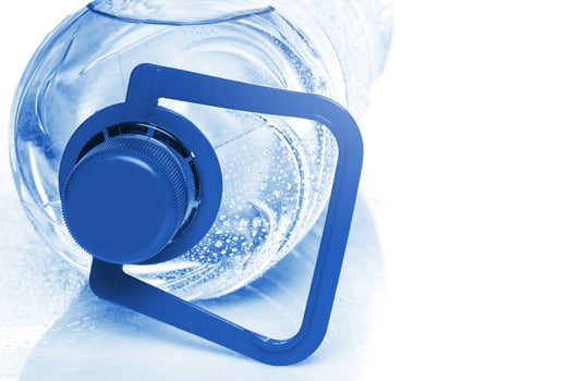 Blue bottle of cold mineral water on white background photo
