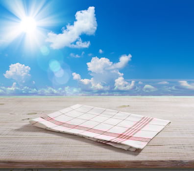 White napkin, table cloth on wooden deck mockup. Summer landscape background. photo