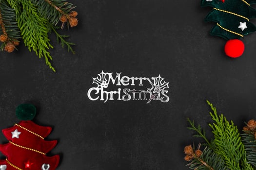 Christmas or New Year dark background with fir branches, Xmas black board framed with season decorations, marry christmas text, view from above. photo