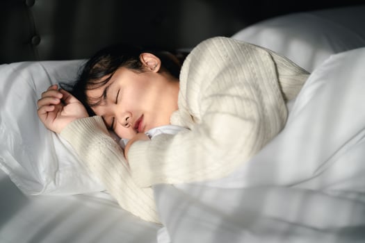 Young woman sleeping on white bed. photo