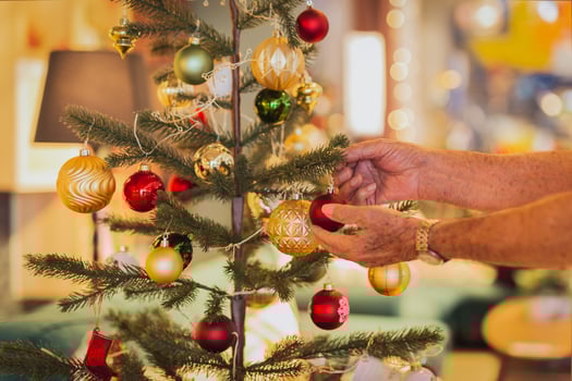 Senior man decorating a Christmas tree at home. photo