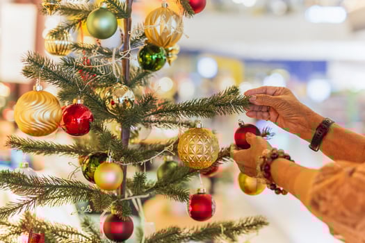 Senior woman decorating a Christmas tree at home. photo