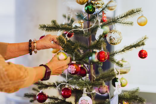 Senior woman decorating a Christmas tree at home. photo