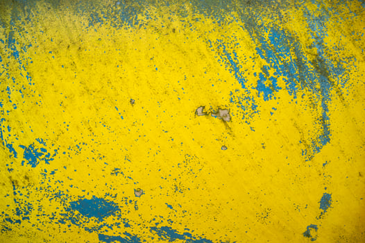 Old wall with scratched peeling blue-yellow paint. Abstract textured background. Copy space. photo