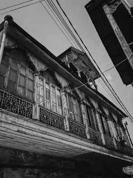 Black and white old antique balcony of a wooden european house. European old architecture. Vertical photo