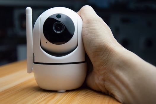 White IP camera placed on wooden floor photo