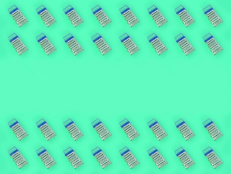 Small stainless steel graters lies on a pastel colored paper. Kitchen accessories. Tools for cooking. Flat lay top view photo