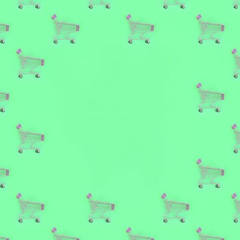 Shopping addiction, shopping lover or shopaholic concept. Many small empty shopping carts perform a pattern on a pastel colored paper background. Flat lay composition, top view photo