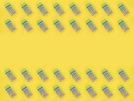 Small stainless steel graters lies on a pastel colored paper. Kitchen accessories. Tools for cooking. Flat lay top view photo