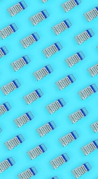 Small stainless steel graters lies on a pastel colored paper. Kitchen accessories. Tools for cooking. Flat lay top view photo