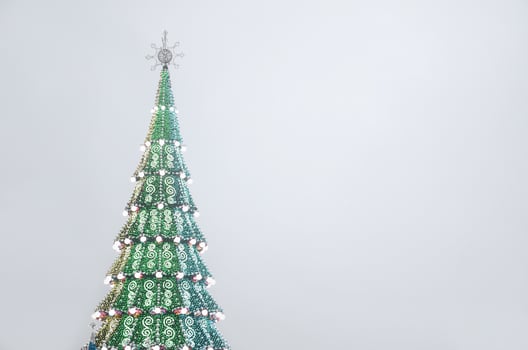 A fragment of a huge Christmas tree with many ornaments, gift boxes and luminous lamps. Photo of a decorated Christmas tree close-up with copy space