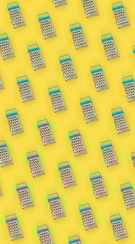 Small stainless steel graters lies on a pastel colored paper. Kitchen accessories. Tools for cooking. Flat lay top view photo