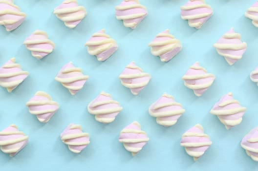 Colorful marshmallow laid out on blue paper background. pastel creative textured pattern. minimal photo
