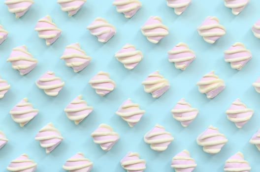 Colorful marshmallow laid out on blue paper background. pastel creative textured pattern. minimal photo