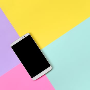 Modern smartphone with black screen on texture background of fashion pastel blue, yellow, violet and pink colors paper in minimal concept photo