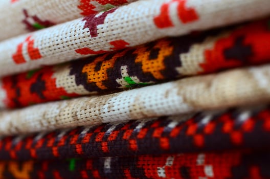 Stack of traditional Ukrainian folk art knitted embroidery patterns on textile fabric photo
