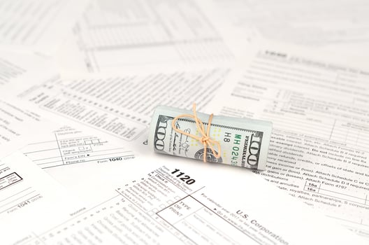 1120 U.S. Corporation income tax return form with roll of american dollar banknotes photo