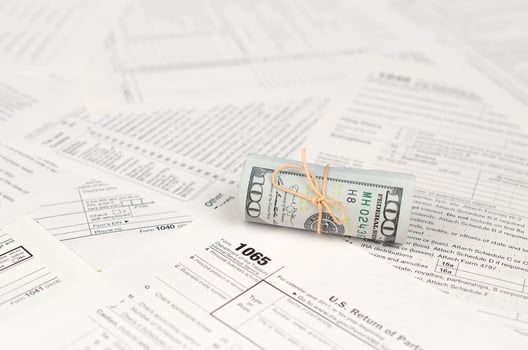 1065 U.S. Return of Parentship Income form with roll of american dollar banknotes photo