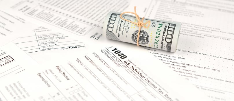 1040 Individual income tax return form with roll of american dollar banknotes photo