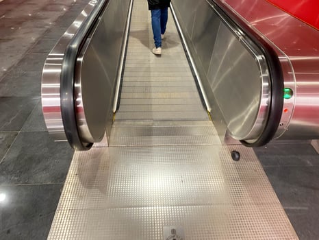 Large red modern long bright underground walkway between metro stations with travel walkers and escalators for quick passage of passengers photo