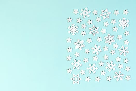 Top view of white snowflakes on colorful background. Winter weather concept with copy space. Merry Christmas concept photo