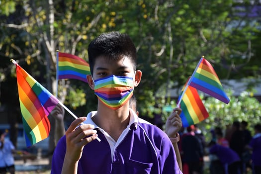 Portrait Asian young boy holds rainbow flag, LGBT symbol, in hands while joining his LGBT activity at school, concept for LGBT community celebration in pride month, June, 2023, around the world. photo