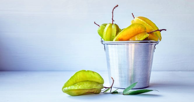 Ripe Starfruit insmall stainless steel basket on white background photo
