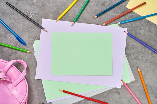 Colored paper and pencils on a light gray background. Education concept, top view of school supplies with copy space for text. Education concept, mockup template for banner photo