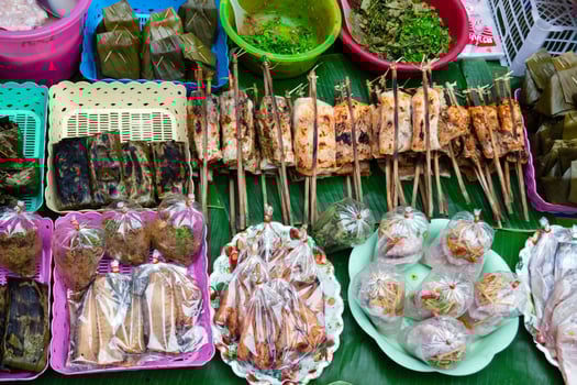 Local dishes from meat, fish, vegetables, fruits, rice and spices on Asian street market. Traditional local morning market in Luang Prabang, Laos. photo