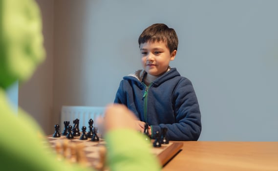 Concentrated Young boy developing chess strategy, playing board game with friend or family at home. Activity or Hobby for Family Concept photo