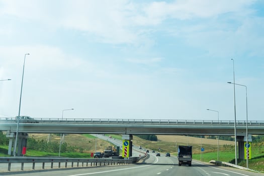 highway with a truck passing under a bridge photo