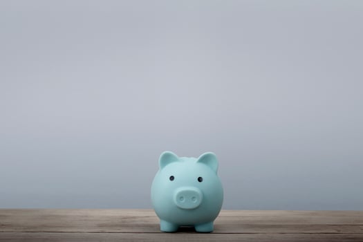 Blue piggy bank with copy space for you text on table background photo