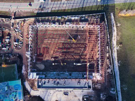 Aerial top down view of construction site with truck cranes and elements of the metal frame. photo