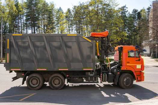 Large truck with manipulator standing on the street, garbage transportation, waste collection, powerful garbage truck photo