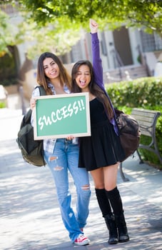 Mixed Race Female Students Holding Chalkboard With Success Written photo