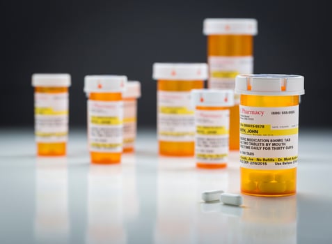 Medicine Bottles and Pills on Reflective Surface With Grey Background photo