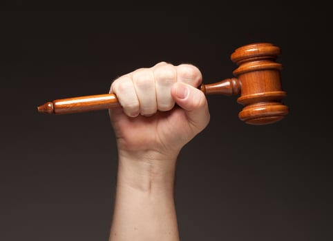 Male Fist Holding Wooden Gavel photo