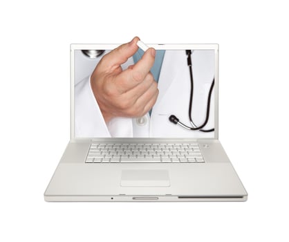 Doctor Handing Pill Through Laptop Screen photo