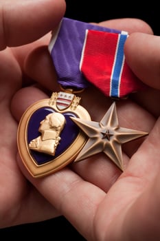 Man Holding Purple Heart and Bronze War Medals photo