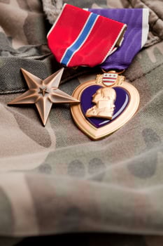 Bronze and Purple Heart Medals on Camouflage Material photo