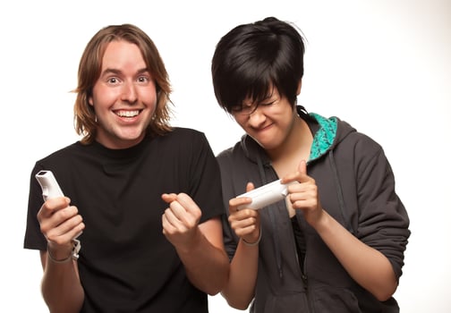 Mixed Race Couple Playing Video Game Remotes on White photo
