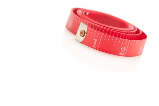 Coiled Red Measuring Tape on White photo