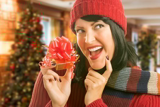 Woman Holding Wrapped Gift in Christmas Setting photo