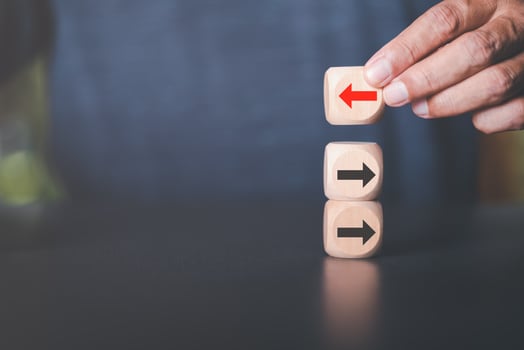 Young businessman selecting wooden blocks with red arrows and different directions Leadership concept and growth of business competition Changing Strategic Vision for Chances of Success photo